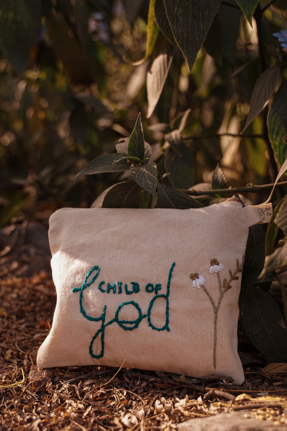 A handmade Sheba Atelier pouch embroidered with the words child of God